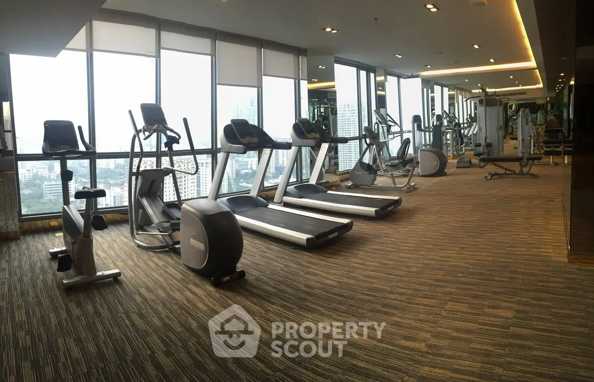 Spacious modern gym with city view and state-of-the-art fitness equipment.