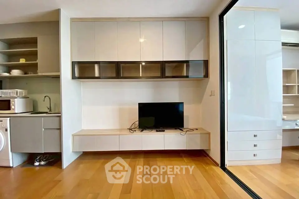 Modern living room with sleek cabinetry and hardwood floors in a stylish apartment.