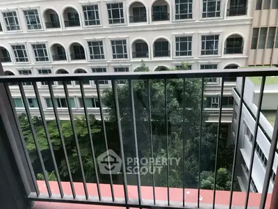 Charming balcony view overlooking lush greenery and elegant building facade.