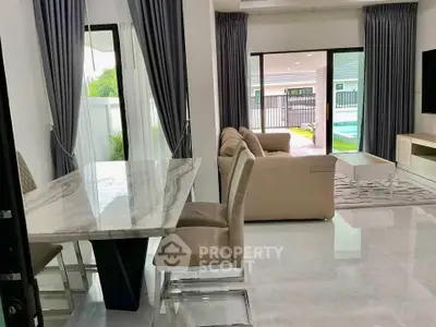 Modern living room with elegant dining area and pool view, featuring luxurious marble table and plush seating.