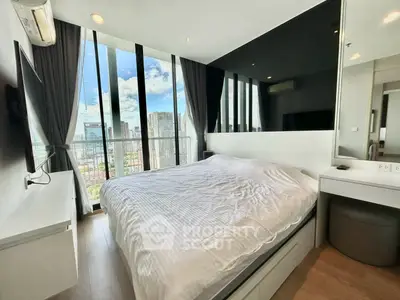 Modern bedroom with floor-to-ceiling windows offering stunning city views in a high-rise apartment.
