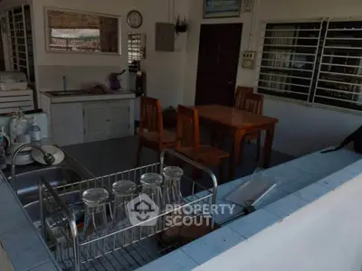 Cozy kitchen with open layout and dining area, featuring wooden furniture and modern amenities.