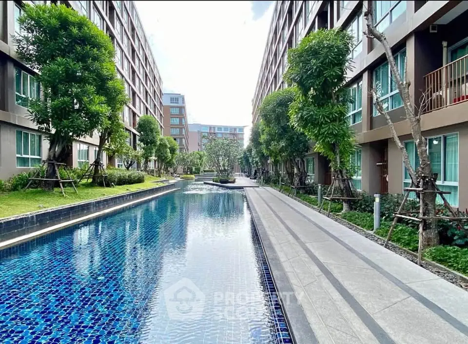 Luxurious apartment complex with stunning pool and lush greenery