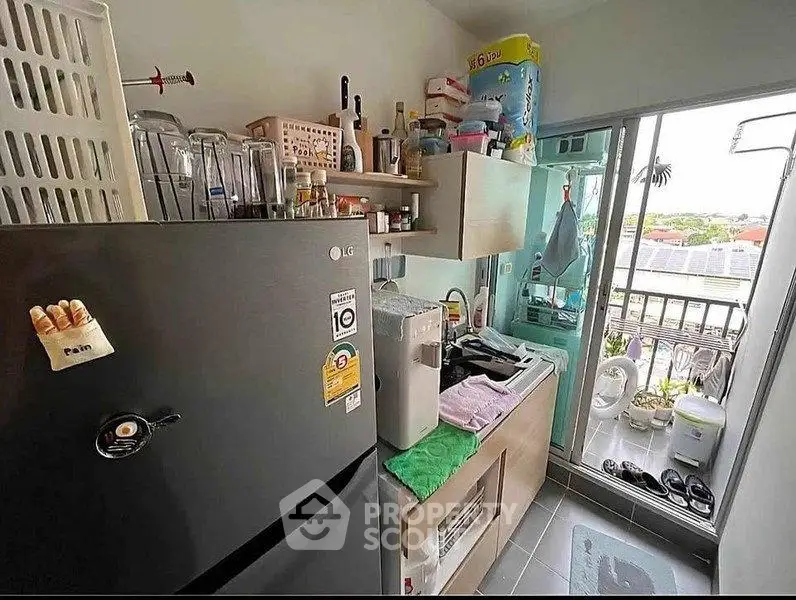 Compact kitchen with modern appliances and balcony view