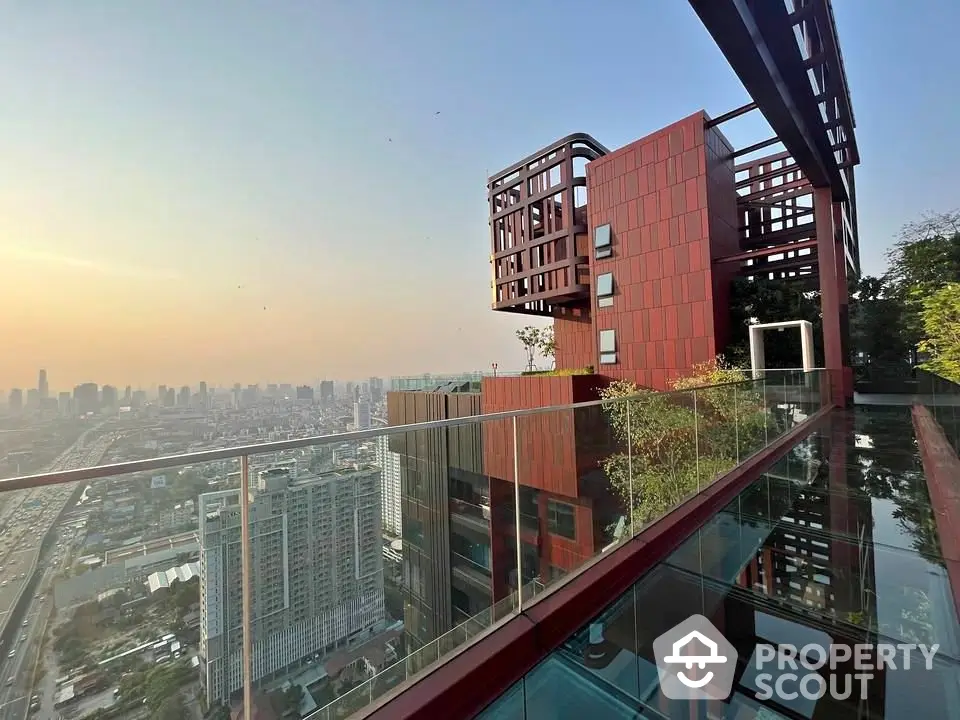 Stunning rooftop view of modern cityscape with unique architectural design and glass railing.