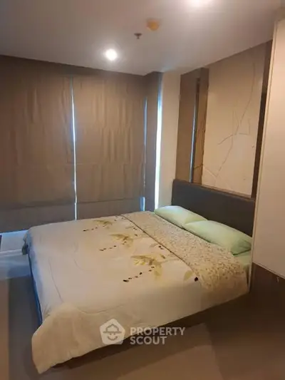 Cozy bedroom with modern decor and large windows for natural light.