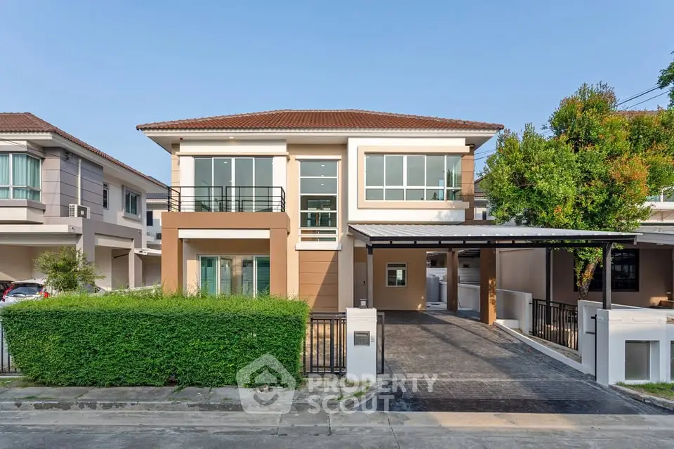 Modern two-story house with driveway and lush greenery in suburban neighborhood.
