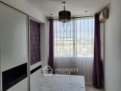 Bright bedroom with large window and modern chandelier