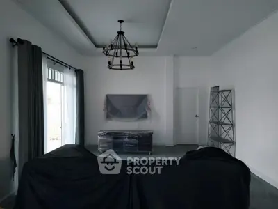 Spacious living room with large windows, modern chandelier, and pre-installed fixtures, ready for customization and personal touches.