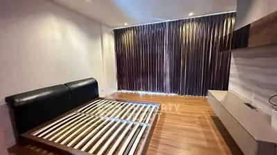 Spacious bedroom with wooden flooring and modern furnishings