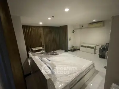 Spacious bedroom with modern furnishings and air conditioning in a well-lit apartment.