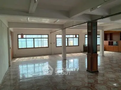 Spacious open-plan living area with large windows and tiled flooring, ideal for customization.