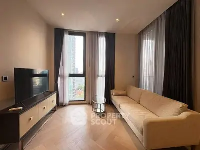 Modern living room with large windows and stylish furniture in a high-rise apartment.