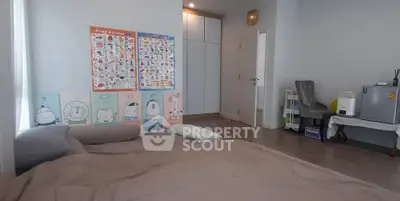 Cozy bedroom with educational posters and compact fridge, perfect for modern living.