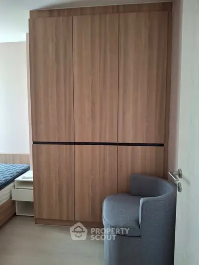 Modern bedroom with sleek wooden wardrobe and cozy chair