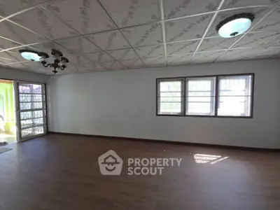Spacious empty living room with wooden flooring and large windows