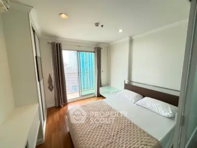 Modern bedroom with city view and balcony access in high-rise apartment