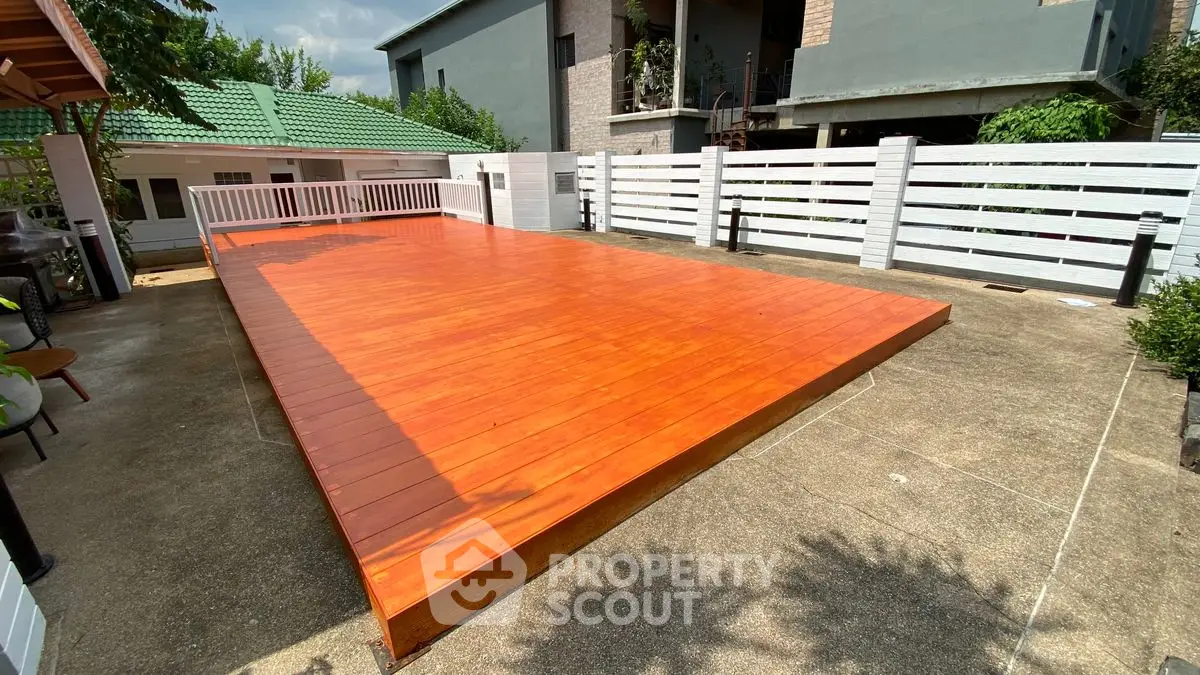 Spacious outdoor deck with modern fencing in a serene residential area.