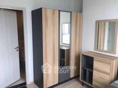 Modern bedroom with stylish wardrobe and mirror, light wood accents.