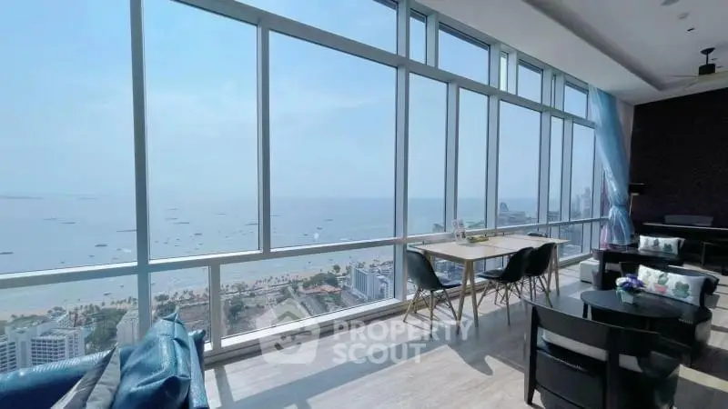 Stunning high-rise living room with panoramic ocean views and modern furnishings.