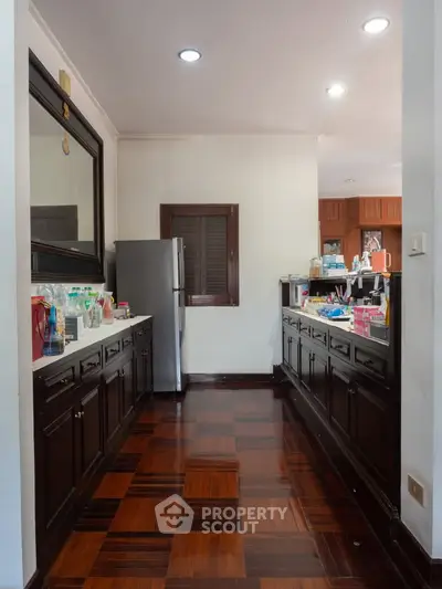 Spacious kitchen with elegant wooden flooring and modern appliances