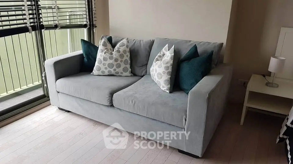 Cozy living room with stylish gray sofa and decorative pillows, perfect for relaxation and comfort.