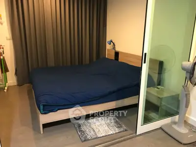 Cozy bedroom with modern decor and sliding glass door, perfect for restful nights.