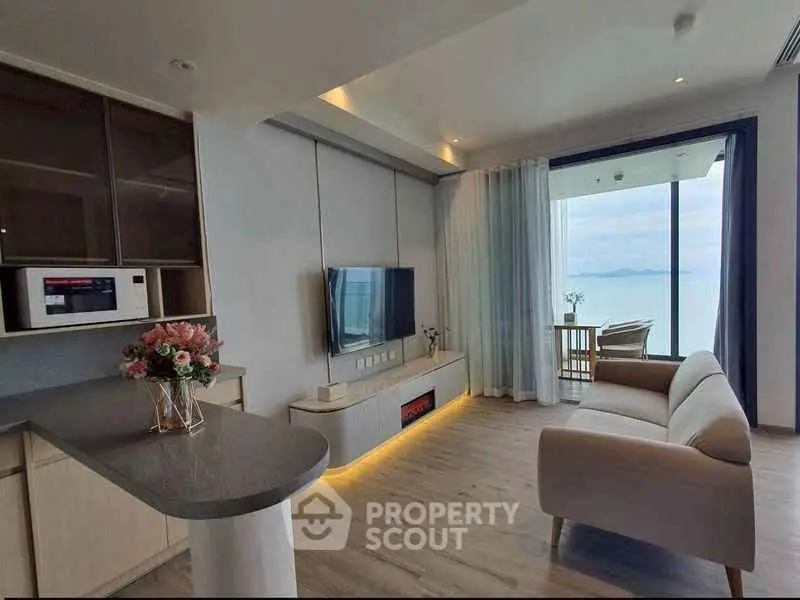 Modern living room with ocean view, sleek furniture, and open layout in luxury apartment.