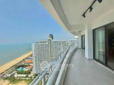 Stunning beachfront balcony with panoramic ocean views in modern high-rise apartment.