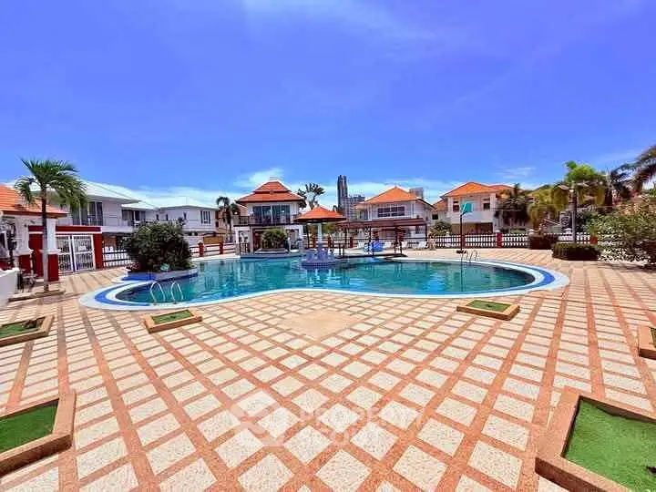 Luxurious outdoor pool area with elegant tile design and vibrant landscaping in a tropical setting.