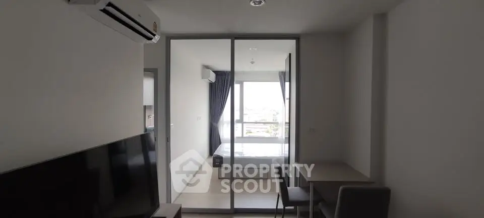 Modern apartment interior with glass partition, air conditioning, and minimalist furniture.