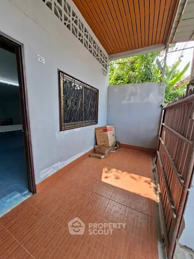 Charming small balcony with tiled flooring and garden view, perfect for relaxation.