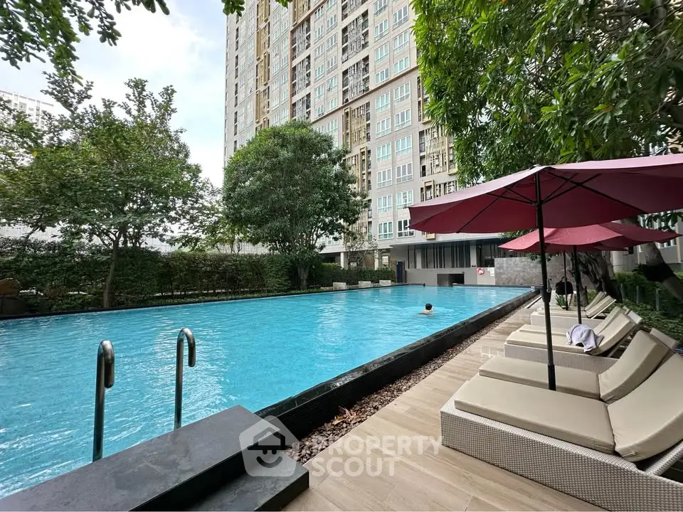 Luxurious apartment complex with a stunning outdoor pool and relaxing lounge area.