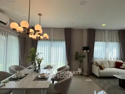 Elegant living room with modern dining area and stylish lighting, perfect for entertaining guests.