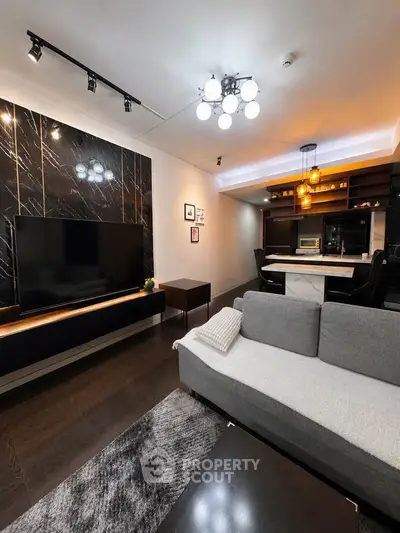 Modern living room with sleek black accents and open kitchen layout