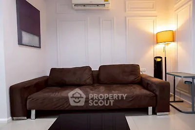 Modern living room with stylish brown sofa and elegant wall paneling