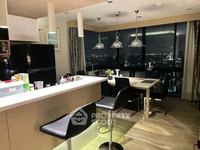 Luxurious open-layout kitchen with stunning city view, modern appliances, and elegant dining area.