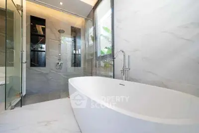 Luxurious modern bathroom with elegant freestanding bathtub and glass shower enclosure.