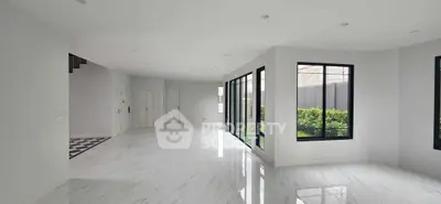 Spacious modern living room with large windows and marble flooring