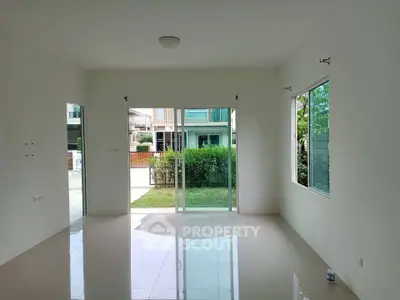 Spacious unfurnished living room with large windows and garden view in modern home