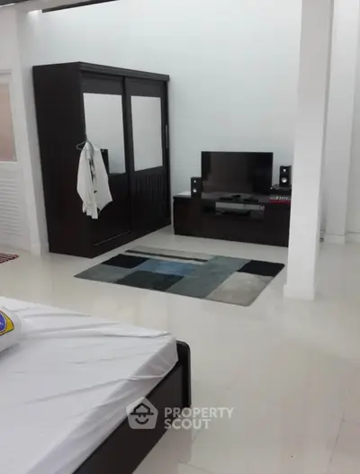 Spacious bedroom with modern wardrobe and entertainment setup