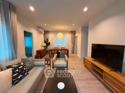 Modern living room with stylish furniture and large TV, perfect for relaxation and entertainment.