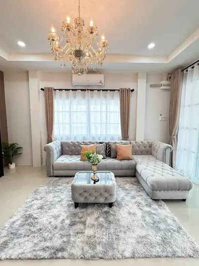 Luxurious living room with elegant chandelier and plush gray sectional sofa.