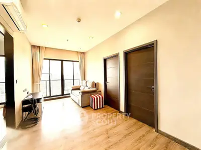 Spacious living room with modern decor and large windows offering natural light.