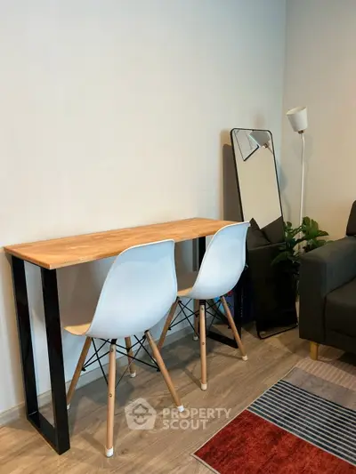 Modern living room with stylish furniture and decor, featuring a sleek console table and contemporary chairs.