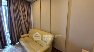 Cozy living room with beige sofa and floor-to-ceiling curtains, perfect for relaxation.