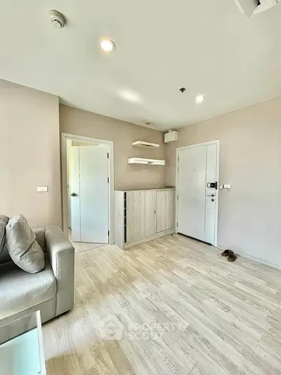 Modern living room with light wood flooring and minimalist decor in a stylish apartment.
