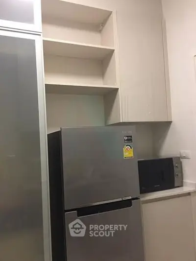 Modern kitchen with sleek fridge and microwave in compact layout