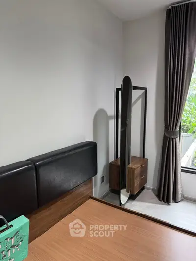 Modern bedroom with stylish mirror and elegant curtains, perfect for a cozy living space.