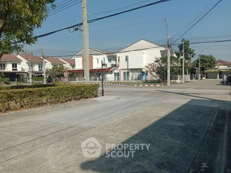 Charming suburban neighborhood with modern houses and clear blue sky.